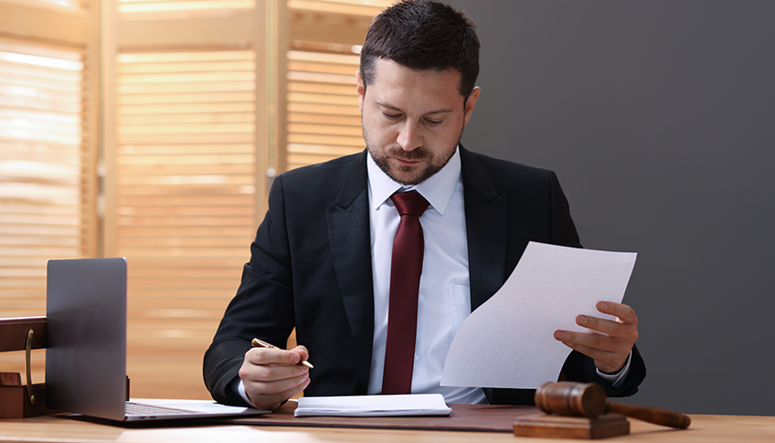 Attorney reviewing case files at a desk