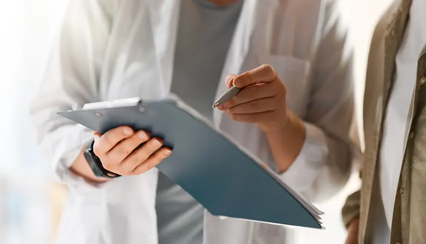 Physician reviewing a patient chart with clinical notes and diagnosis terminology